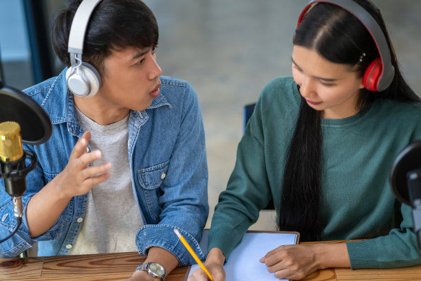 现代的年轻男女在演播室里讨论和录制播客。图片下载
