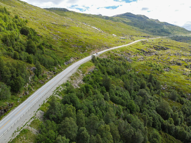 无人驾驶飞机的照片。从挪威山谷的上方俯瞰，远处有一条汽车乡村公路穿过山谷。图片下载