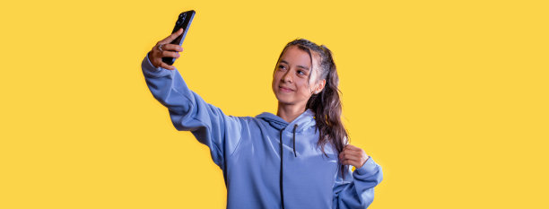 生活方式:黄色背景的年轻拉丁人通过智能手机上传内容到网络图片下载