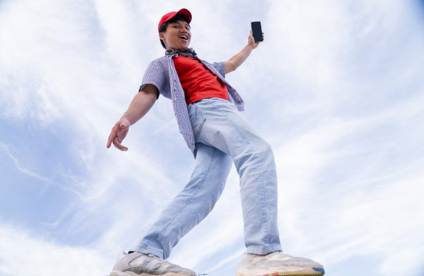 快乐的人在蓝天的背景。在蓝天的背景下，一个快乐微笑的亚洲男人的肖像照片。图片下载