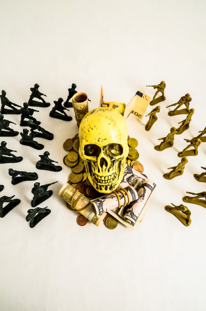 在一堆钱和士兵上面放着一个骷髅头图片下载