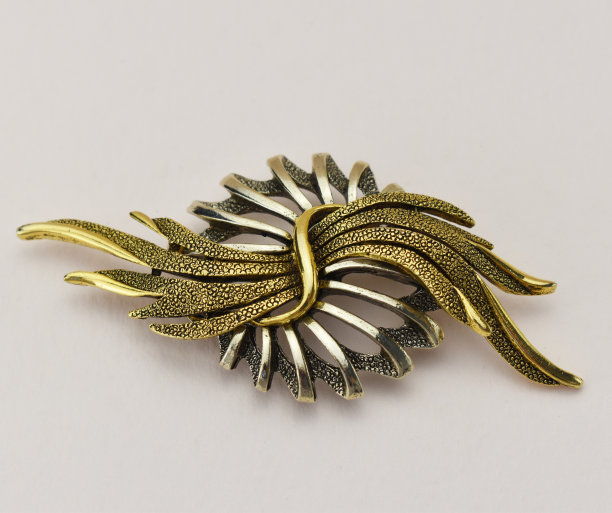 金色和银色的复古胸针米色背景，强调复古的珠宝为妇女，宣传照片为网上珠宝店图片下载