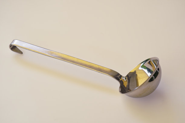 高角度的银色勺子躺在白色的户外照片桌上。图片下载