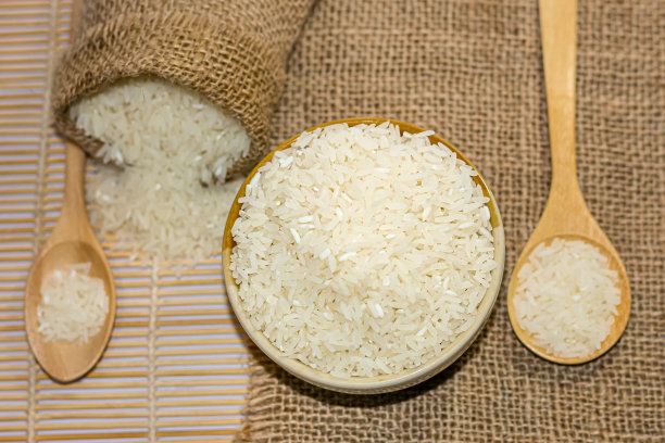 茉莉花大米泰国放在勺子和碗上的麻袋与特写照片的风格。图片下载