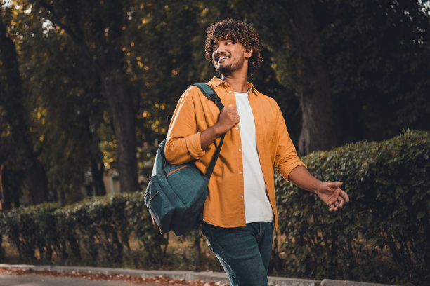 阳光明媚的春日，开朗积极的好男人学生上完大学课后回家或宿舍的照片图片下载
