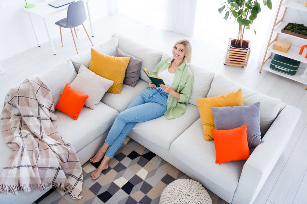 照片可爱可爱开朗的女孩度过周末假期在家里看书业余时间坐在沙发上图片下载