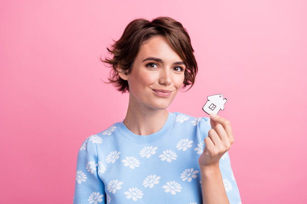 照片中的积极的人手臂的手指持有显示小纸房子孤立在粉红色的背景图片下载