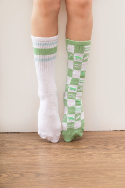 孩子穿了一双不同的袜子。孩子的脚穿着不匹配的袜子，摄影棚里的照片。唐氏综合症意识概念，奇数袜子日，反欺凌周。图片下载