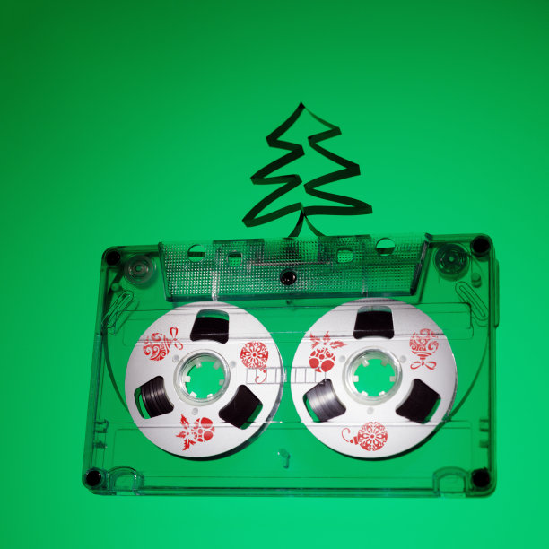广场照片与旧录音带和圣诞树从磁带绿色背景。这张照片是一张圣诞音乐CD的封面，上面有空白的文字空间。圣诞玩具的红色图案图片下载