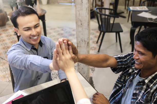 多民族商业同事在会议中击掌的照片图片下载