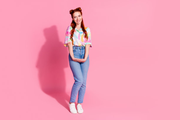 漂亮乐观的女孩穿着彩色衬衫牛仔裤裤子站在一起的手孤立的粉红色背景的全尺寸照片图片下载