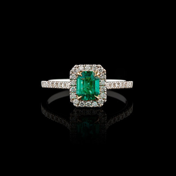 美丽的白金戒指与钻石和祖母绿在黑色的背景图片下载