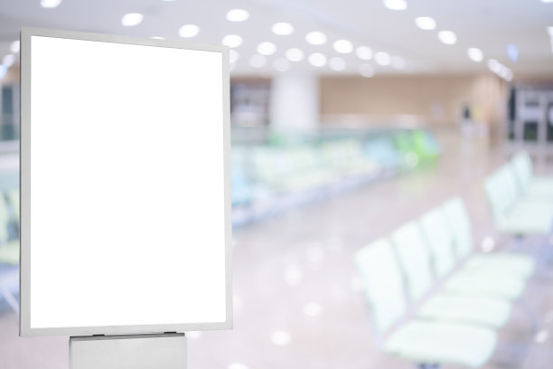 一张空白的白色海报的模型，挂在现代医院候诊室的墙上，有舒适的椅子和医疗用品。图片下载