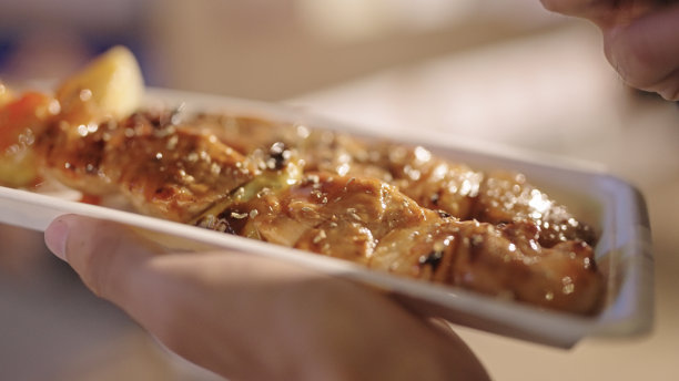 一个人在夜市给食物拍照。图片下载