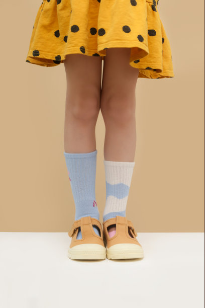 孩子穿了一双不同的袜子。孩子的脚穿着不匹配的袜子，摄影棚里的照片。唐氏综合症意识概念，奇数袜子日，反欺凌周。图片下载