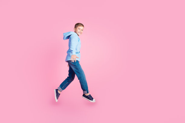 小精力充沛的小学生的全身侧面照片跳跃空白空间广告孤立的粉红色背景图片下载