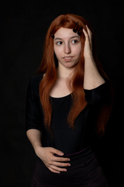 一个美丽的红发女人在黑色背景的肖像照片图片下载