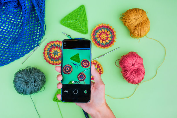 女人的手在浅绿色的背景上制作了一幅钩针布局的图片。图片下载