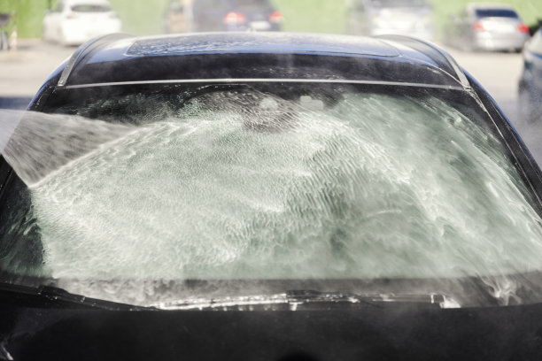 在洗车站高压枪清洗汽车挡风玻璃的裁剪图片。图片下载