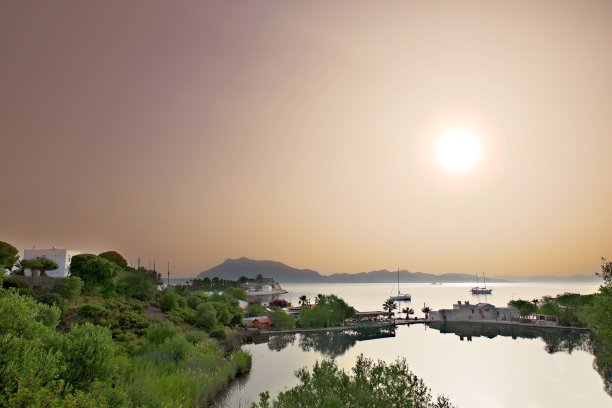 一个美丽的日出照片与热湖，海，码头和城市的看法，在一个受欢迎的度假胜地图片下载