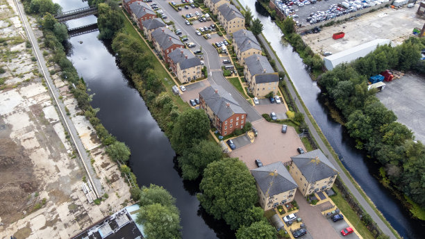 这是英国西约克郡利兹市中心运河旁的现代住宅区，航拍照片显示，这些崭新的房子两边都是水，建筑工作正在进行图片下载