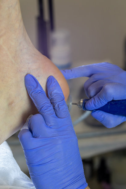 年轻女子在美容院用铣刀修脚，特写图片下载