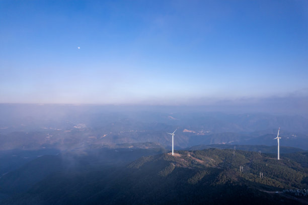 在阳光明媚的山顶上，风力涡轮机的航拍照片图片下载
