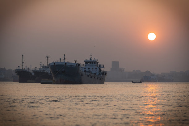 日落时分，吉大港的船只在水面上图片下载