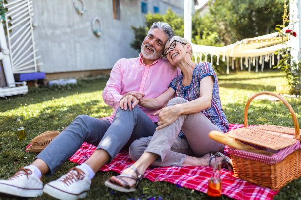 老夫妇坐在花园里拥抱，在户外野餐的照片图片下载