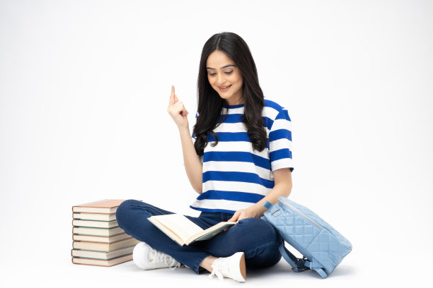 全身尺寸的年轻女孩读书坐在地板上穿着牛仔裤牛仔粉t恤鞋孤立在白色背景股票照片图片下载