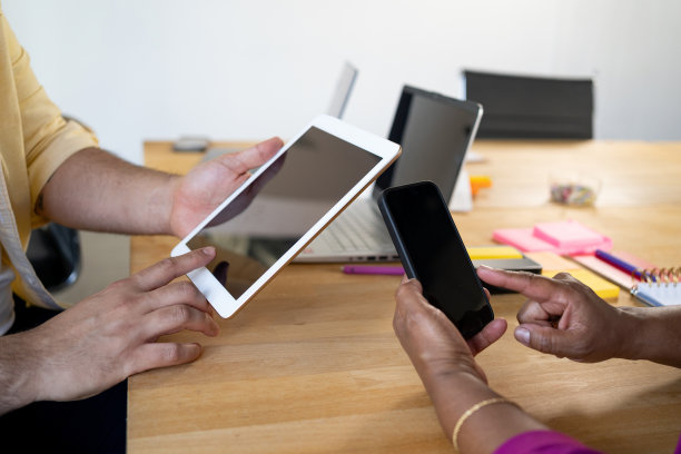 办公室里拿着Ipad和手机的人的特写图片下载