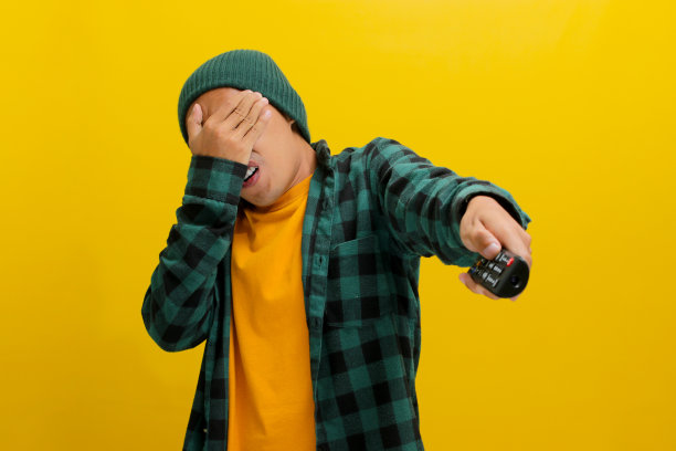 害怕的年轻亚洲人看恐怖电影从他的手指偷看图片下载