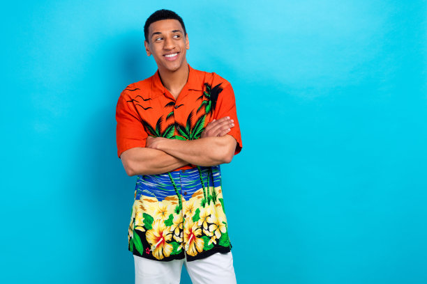 照片的自信梦幻的家伙穿着印花衬衫手臂折叠看着空的空间孤立的蓝色背景图片下载