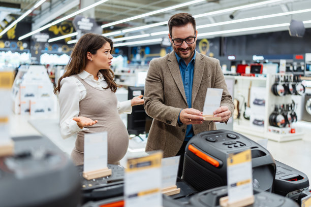 年轻夫妇在现代科技商店买东西。图片下载