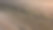 这是一张粗糙不平的地面特写照片，可以看到轮胎的痕迹和散落的小岩石。图片下载