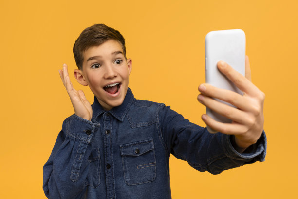 神奇的报价。惊讶的少年兴奋地看着智能手机屏幕图片下载