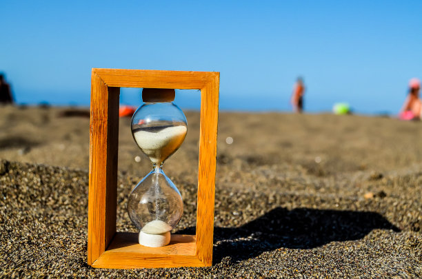 沙滩上放着一个木盒，里面装着一个玻璃钟图片下载