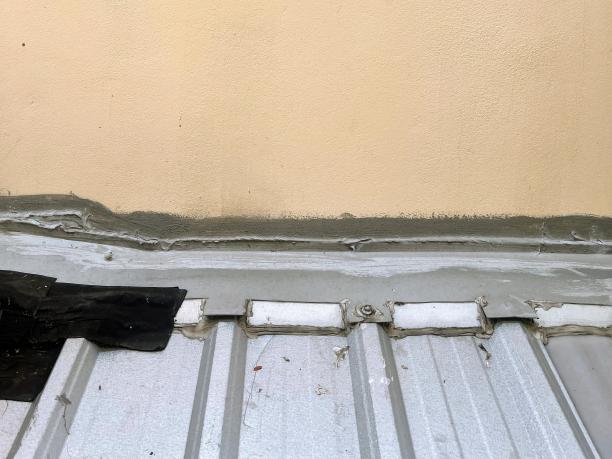 金属屋顶上一把黑色雨伞的照片。图片下载