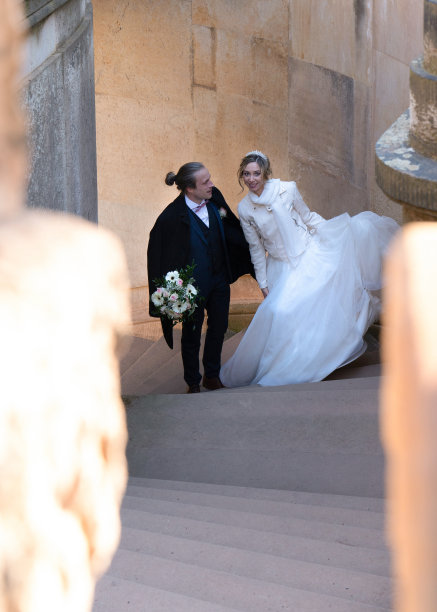新婚夫妇的散步。新娘和新郎走上台阶。照片通过列。图片下载