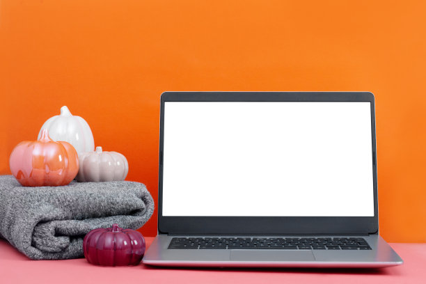 笔记本电脑放在桌子上，最小的秋天或秋天的装饰，橙色，季节性的商业概念图片下载