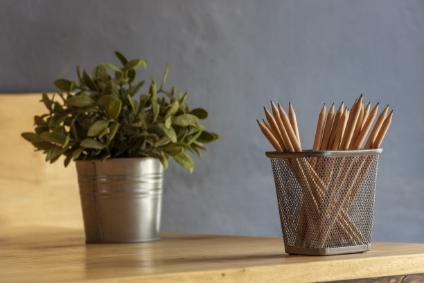 花盆、尖铅笔、花瓶、办公用品、木桌装饰。绿色装饰家庭办公桌。绿色植物花瓶上的木材办公室书桌削笔具盒花卉室内植物家庭办公室装饰桌子图片下载