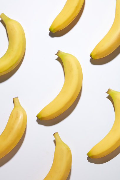 独特的香蕉主题模板，为天然水果原产地产品的推广，大量的黄色香蕉整齐地排列在白色的平面上。照片采用高角度拍摄，留有设计空间图片下载