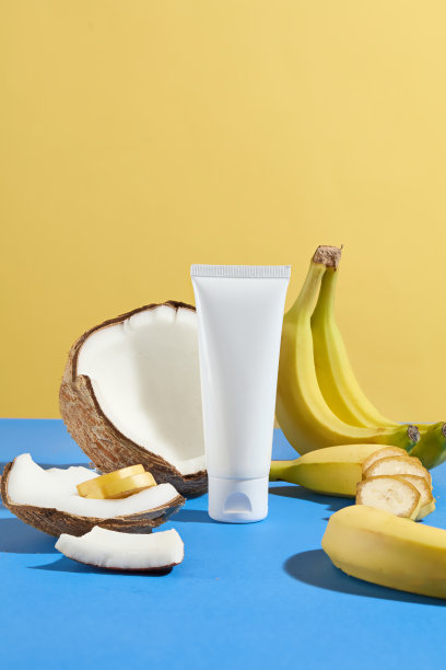 垂直相框的美容产品广告照片，从天然水果中提取，热带风格，黄蓝色调，一个未标记的管包围香蕉和椰子图片下载