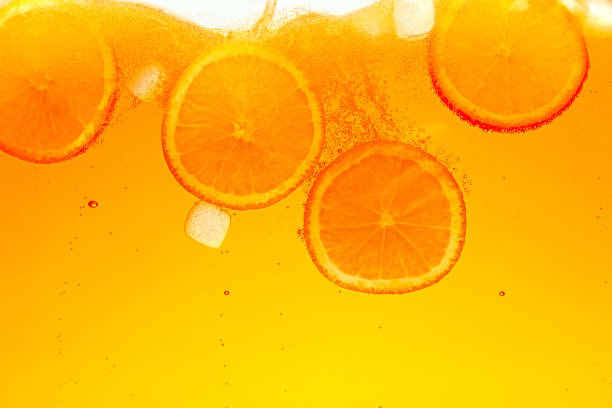 变形的照片。在气泡饮料中，有趣的气泡围绕着饱满的橘子片。抽象的壁纸。图片下载