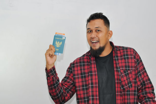 旅行者快乐的男人穿着休闲的衣服，红色的衬衫，拿着护照，机票隔离在白色的墙上，航空旅行的旅程概念图片下载