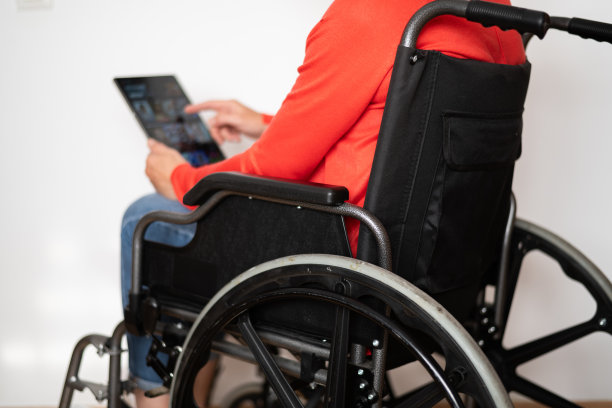 轮椅上的残疾人在白色背景下寻找电影或电视连续剧来观看。图片下载