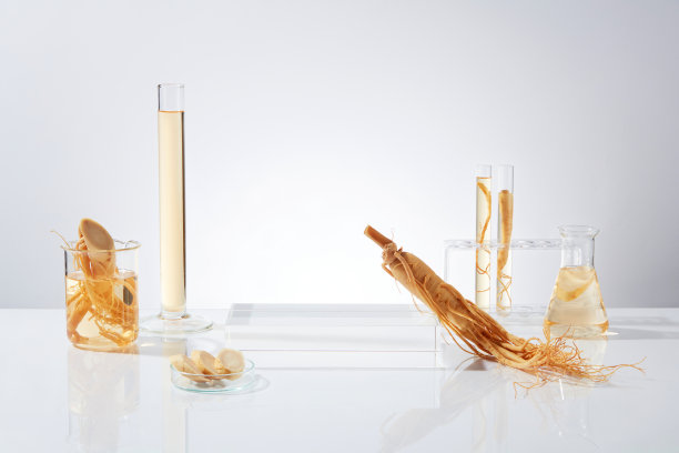 白色背景的正面照片，中间是一个空的讲台，上面倚着一根人参，旁边是量筒、烧杯、试管和erlenmeyer，所有物品都含有黄色液体图片下载