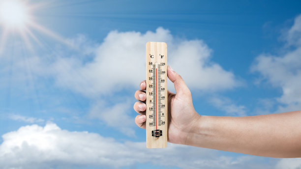 人类手握温度计与热温度与天空背景图片下载
