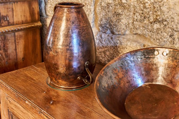 古色古香的铜壶和铜碗，以质朴的石头为背景图片下载