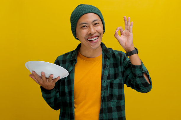 亚洲男人拿着一个空盘子，用OK的手势表示美味图片下载